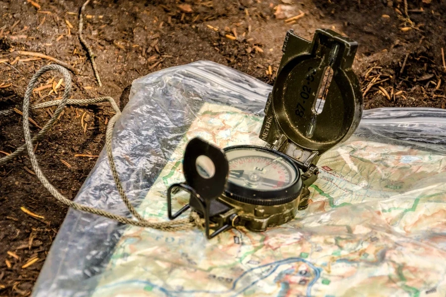 Military compass opened sitting on top of map