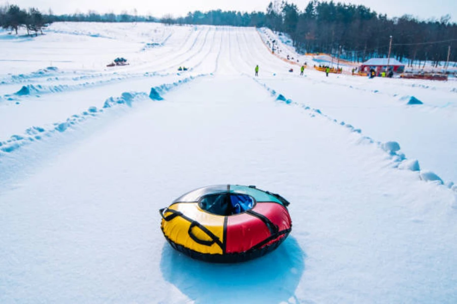 Multi-colored inflatable snow tube at the base of a hill