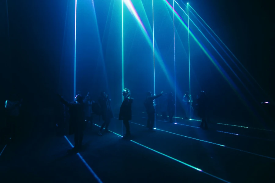 People performing on a stage lit by laser lights