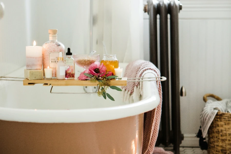 Pink freestanding bathtub with metal and bamboo tray