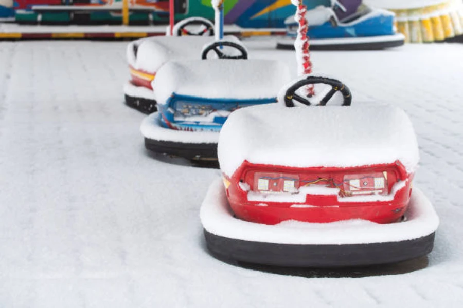 Row of bumper cars lined up and covered in snow