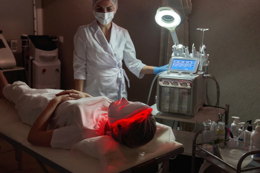 Skin expert monitoring client using LED facial mask