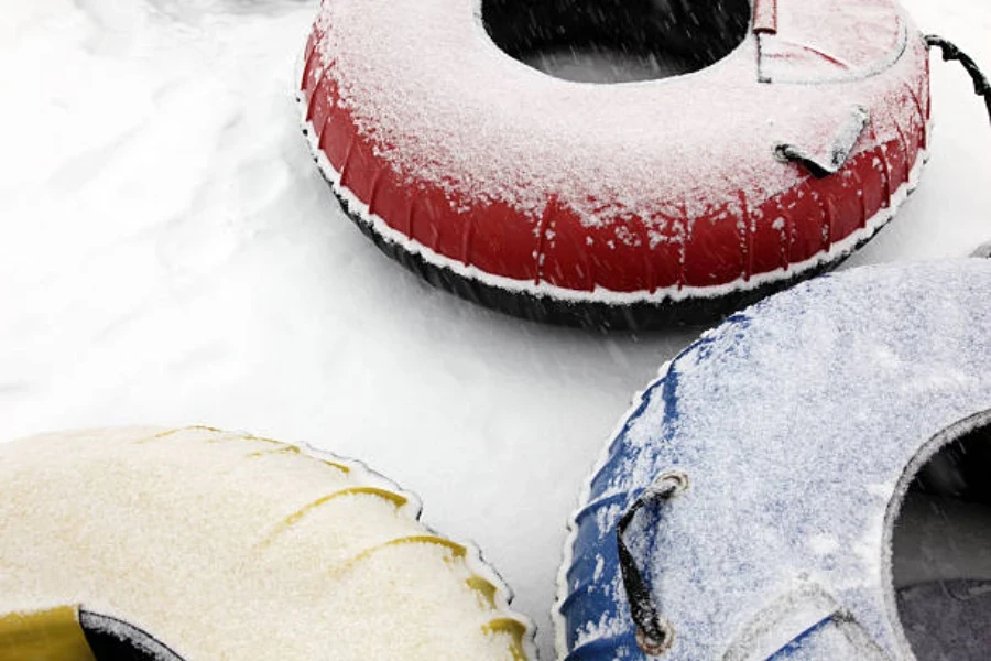 Three colorful snow tubes sitting with fresh snow on top