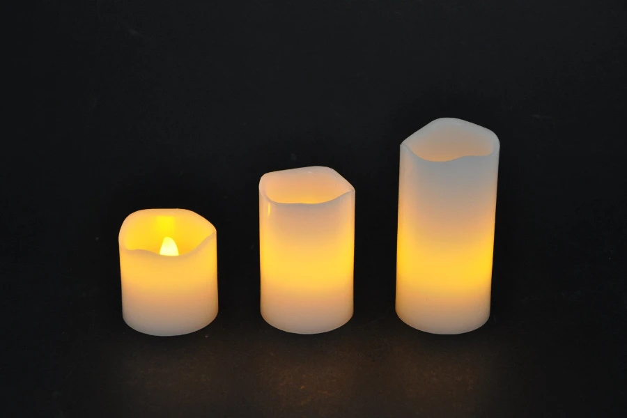 Three pillar candles on a black background