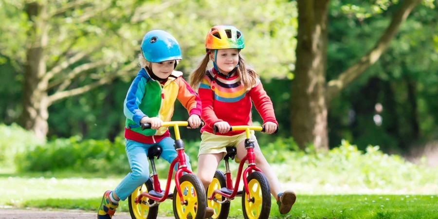 two girls riding balance bikes