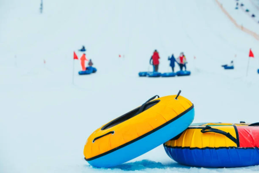 Two large inflatable snow tubes at the bottom of hill