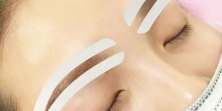 Woman using a pair of white eyebrow stencils