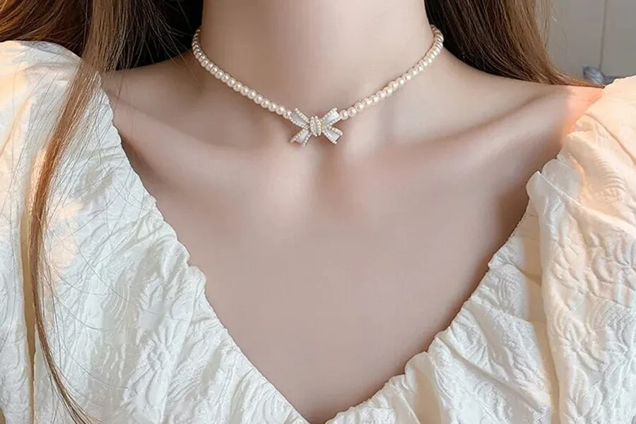 Woman wearing a coquette pearl ribbon necklace