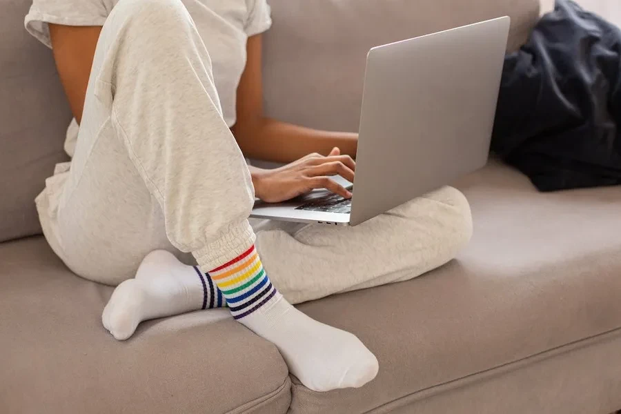 Woman wearing gray sweatpants working on a laptop