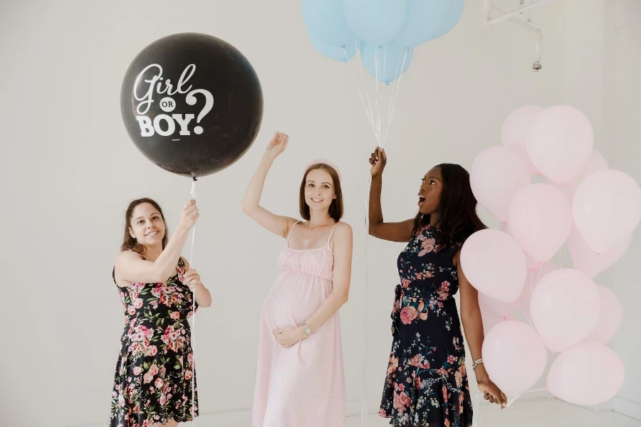 Mujeres sosteniendo globos para fiesta de revelación de género