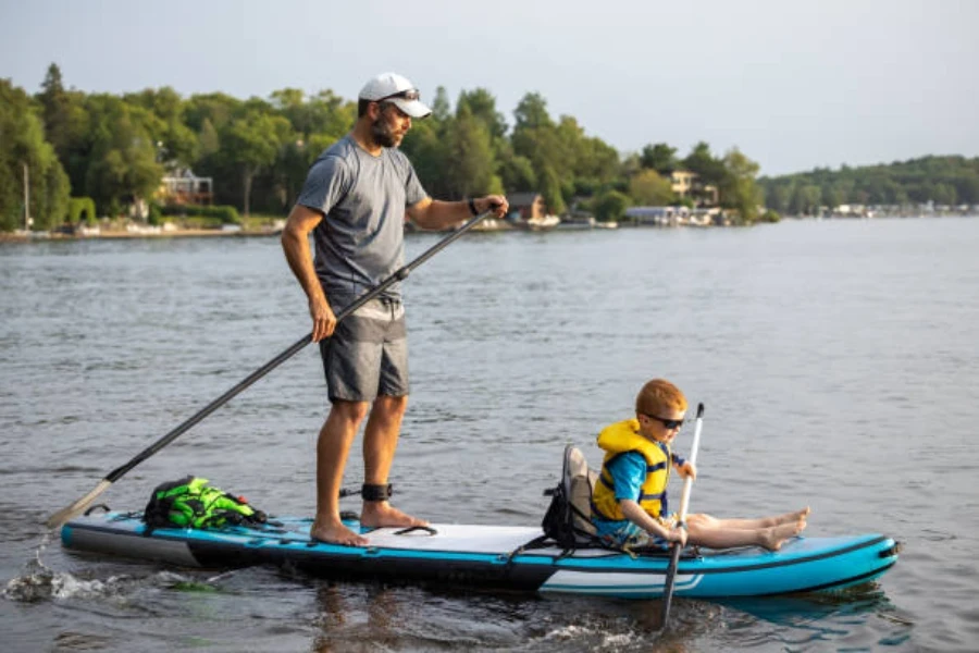 Joven sentado en paddle board vistiendo chaleco salvavidas