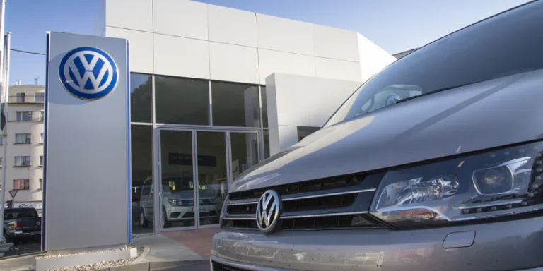 Car with Volkswagen logo in front of dealership building
