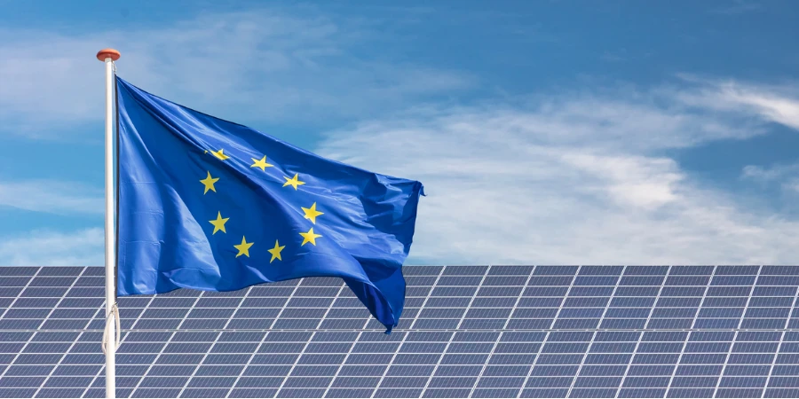 Bandiera dell'Unione Europea davanti a una vasta gamma di pannelli solari