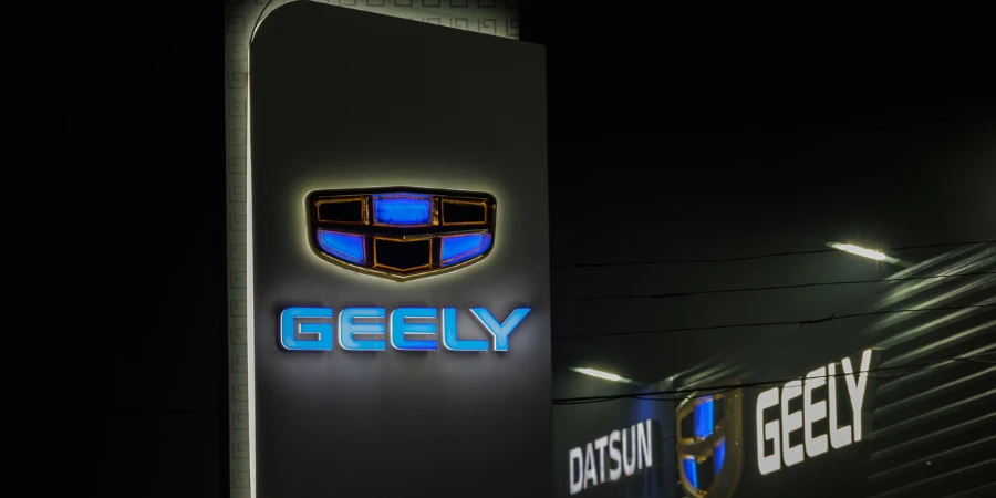 Logo Geely sul pilastro della concessionaria auto e sull'edificio nella notte nebbiosa