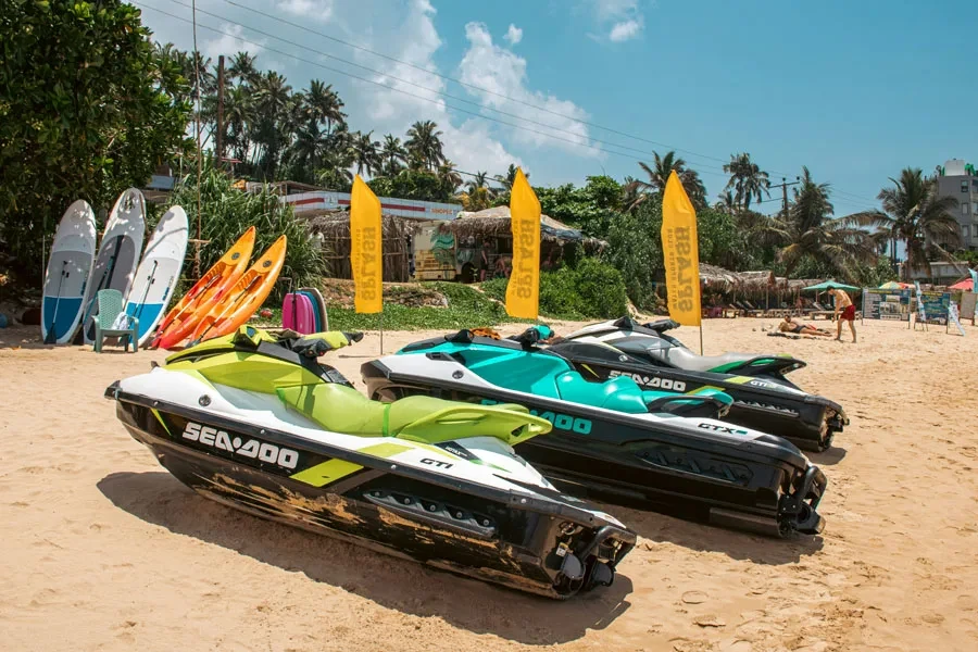 Jet skis and other water sports equipment on a beach