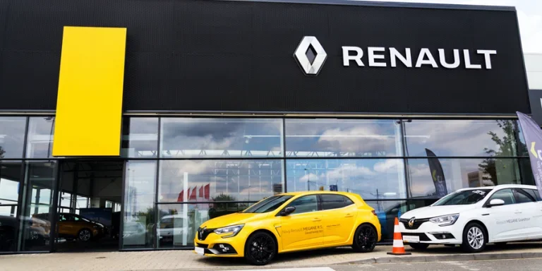 Renault company logo on car in front of dealership building