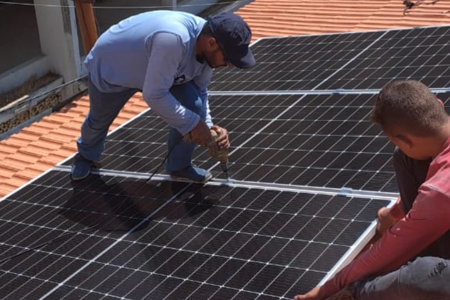 A man installing solar panels on a roof