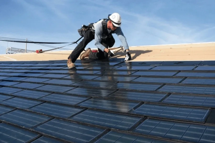 Um homem instalando telhas solares