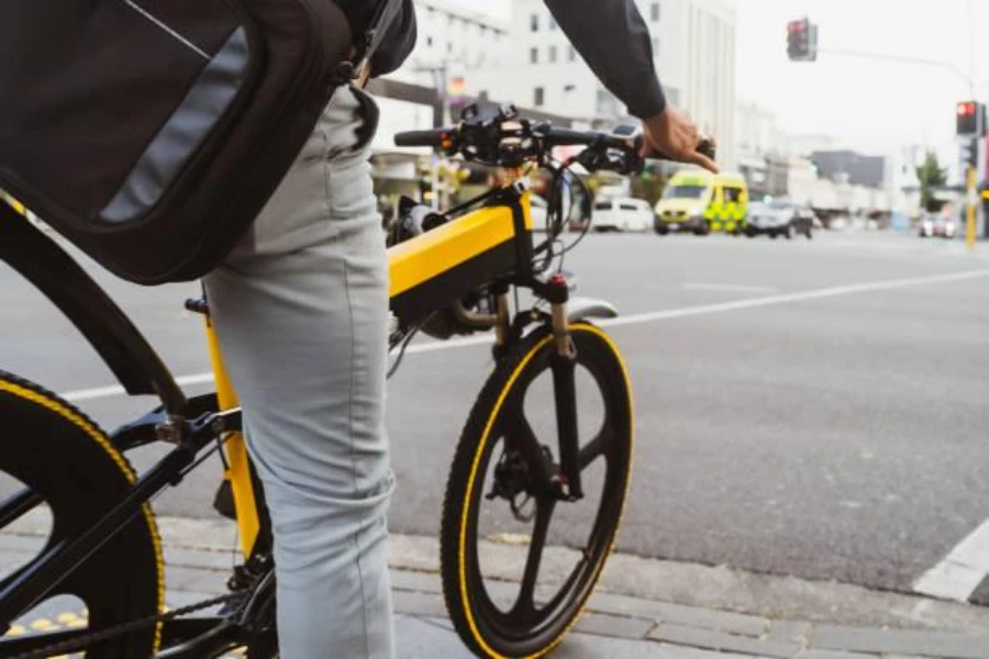 A man on a black and yellow electric bicycle