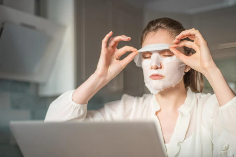 una mujer aplica mascarilla facial