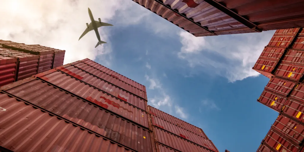 Airplane flying above container logistic