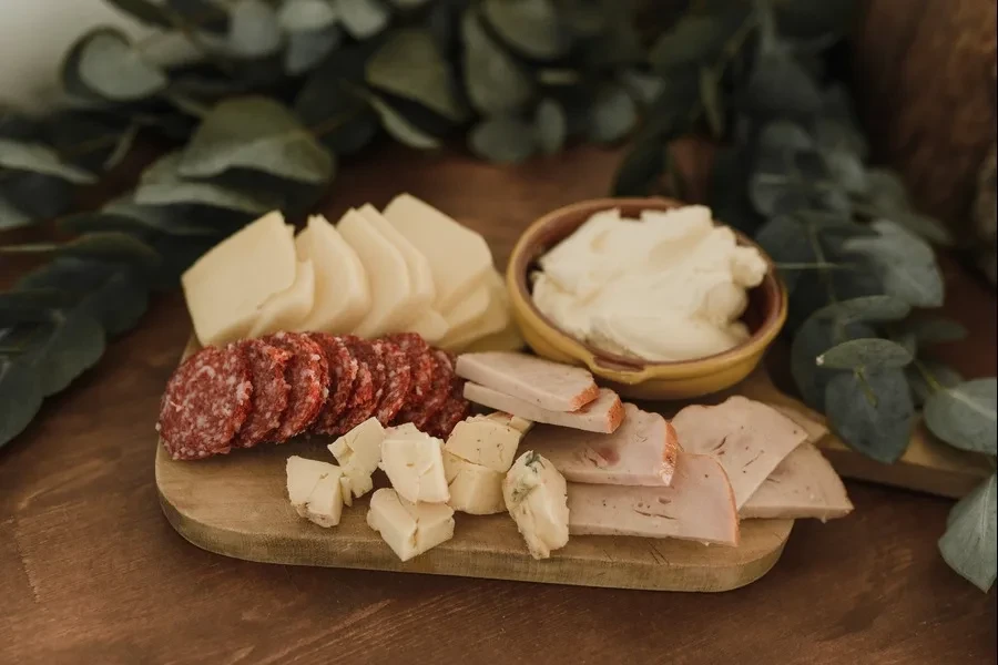 Berbagai macam makanan di papan charcuterie kayu