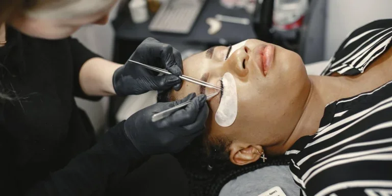 Kosmetikerin repariert Wimpernverlängerungen für den Kunden