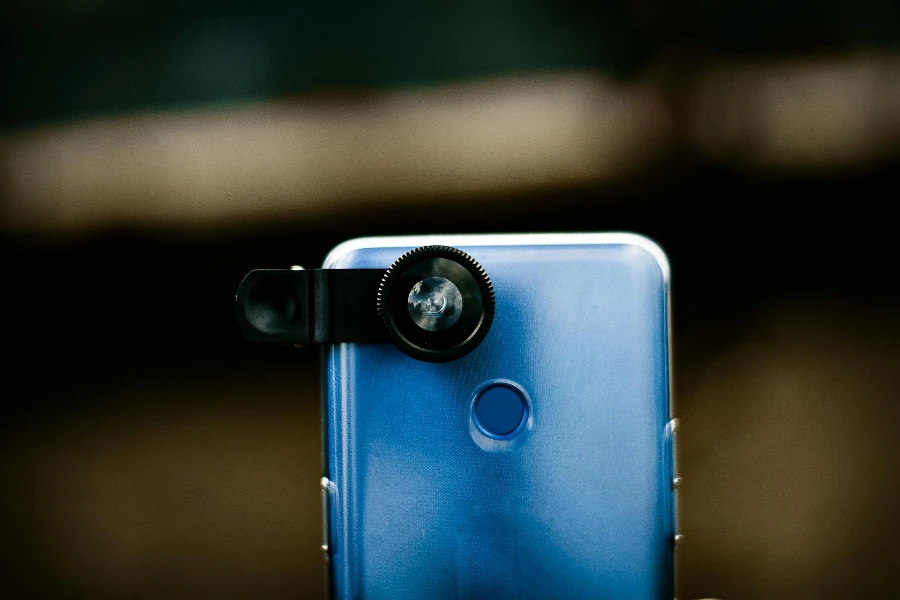 Синий смартфон с прикрепленным объективом камеры