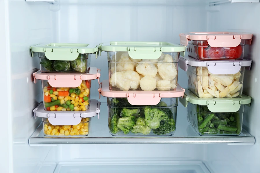 Containers with frozen food in refrigerator