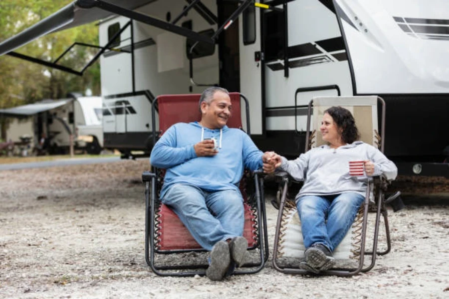 Paar sitzt in Liegestühlen und trinkt eine Tasse Kaffee