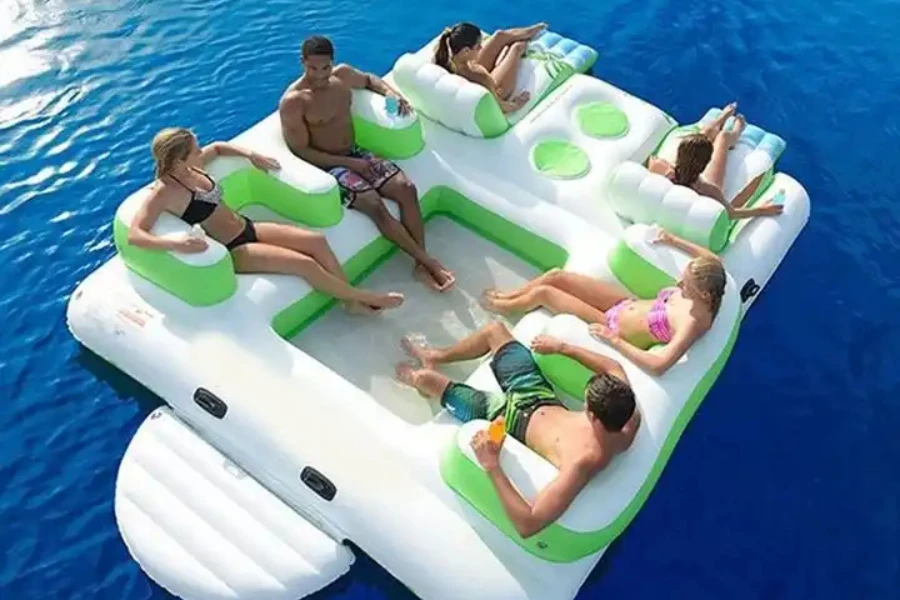 Amigos relajándose dentro de una gran piscina inflable con isla flotante