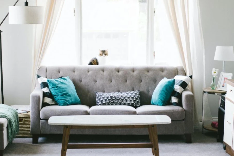 Серый диван с полосатыми подушками и принтом совы