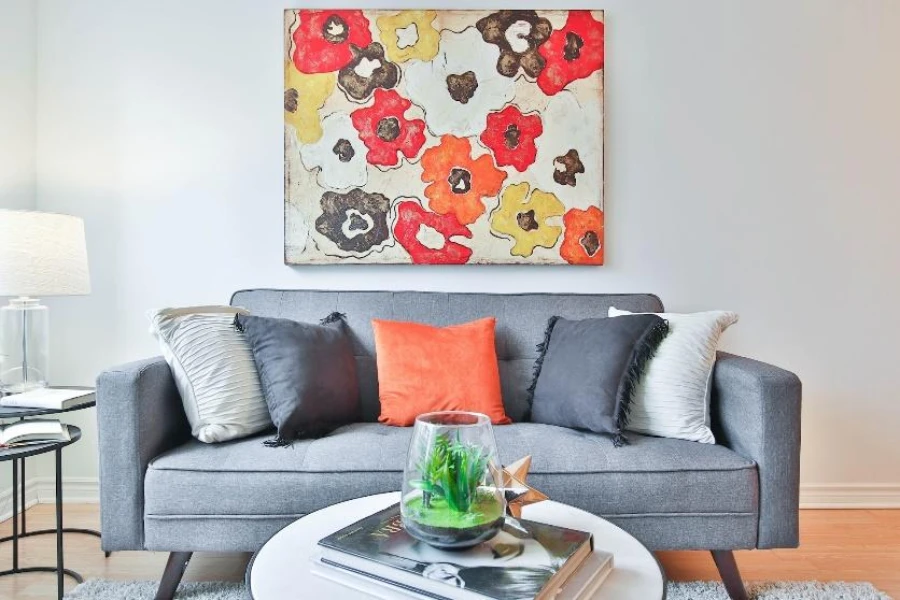 Gray living room sofa with orange and gray pillows