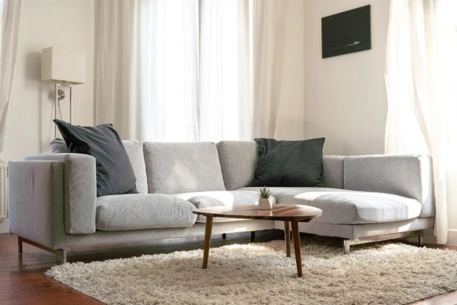 أريكة مقطعية باللون الرمادي مع وسائد كبيرة الحجم باللون الرمادي الداكن