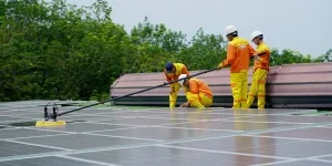 Gruppe von Solartechnikern, die Solarmodule reinigen