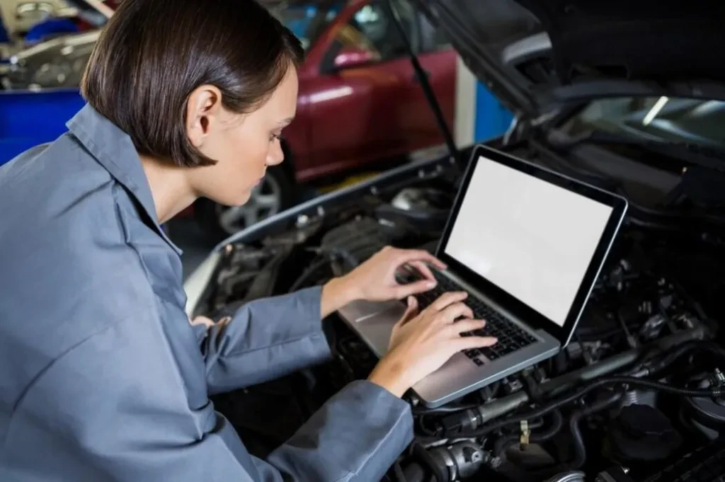 un ingeniero utiliza una computadora portátil para tuning de automóviles