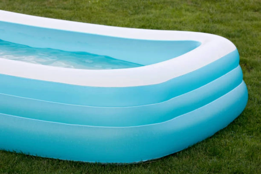 Light blue and white inflatable pool sitting on grass