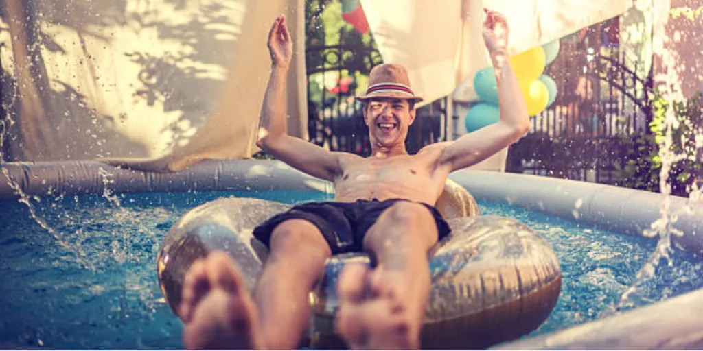Man sitting in donut inside a small inflatable pool