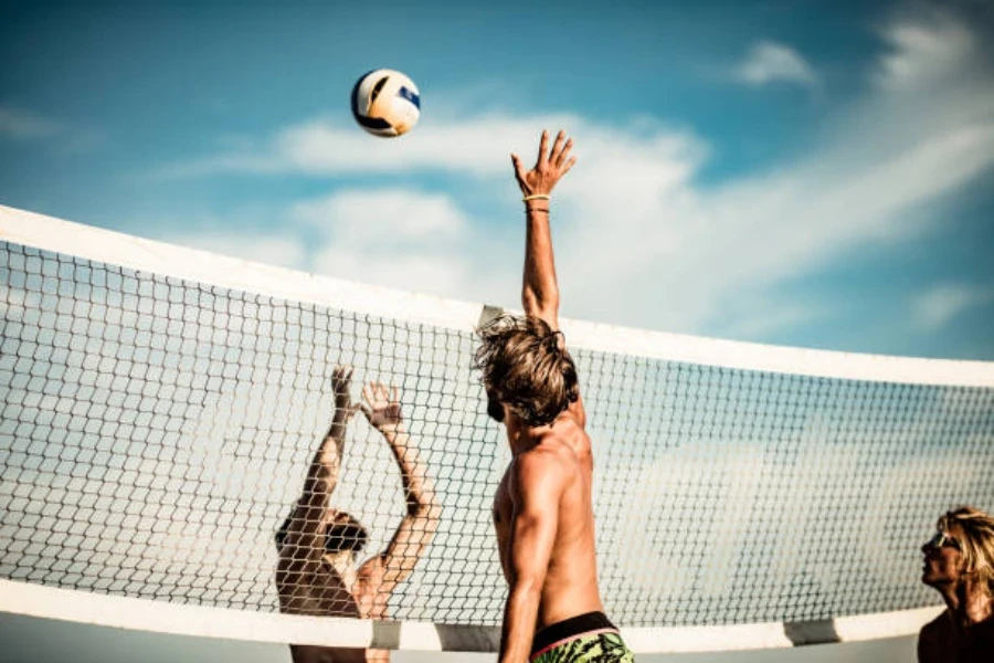 Men playing beach volleyball on a sunny day