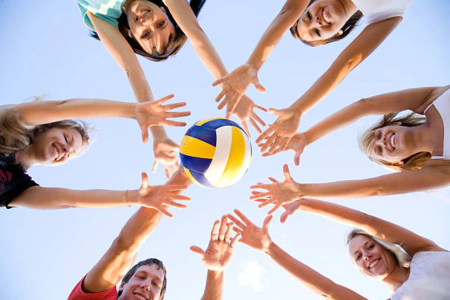 Menschen im Kreis blicken auf den Volleyball in der Mitte