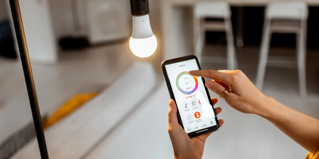 person controlling smart LED light bulb with smartphone