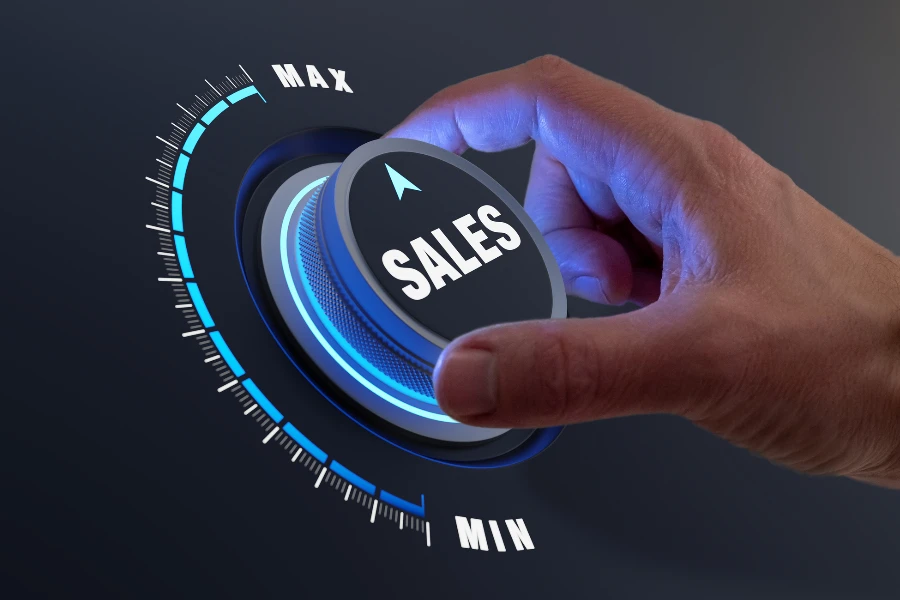 Person turning a dial that reads SALES
