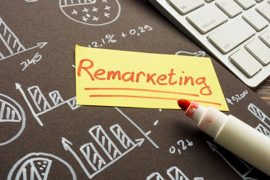 REMARKETING escrito em post-it com gráficos em segundo plano