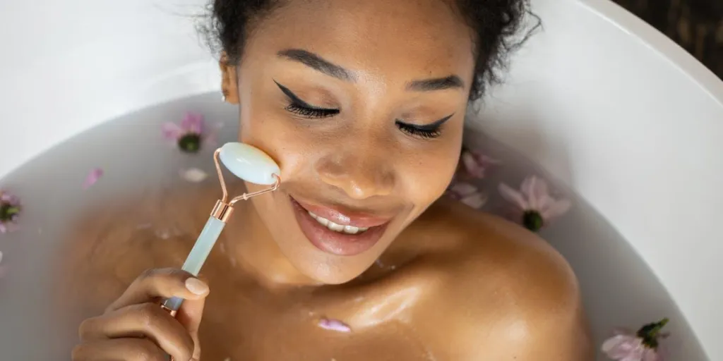 Smiling woman using derma rollers in a bathtub
