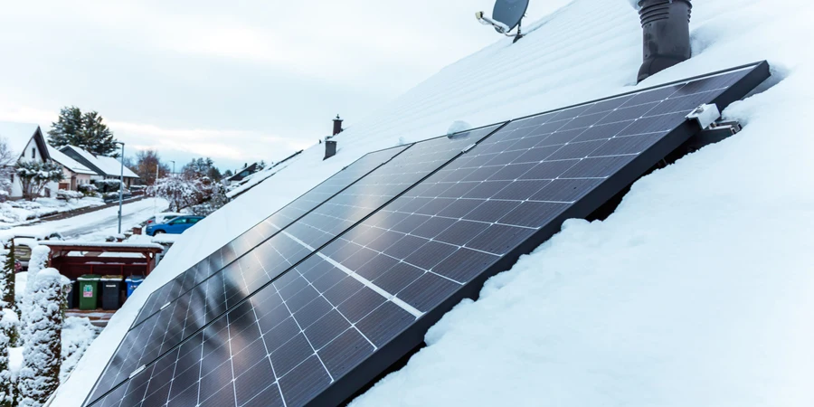 panel surya di atap dengan salju