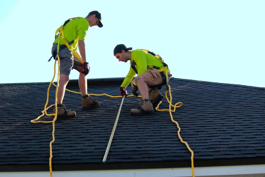 Solar technicians measuring a solar-roofed wall