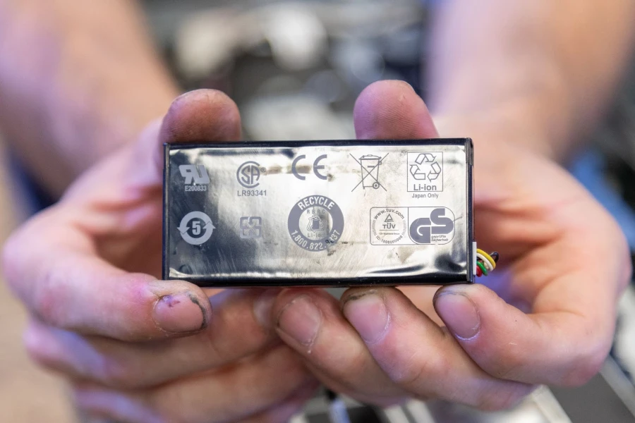 Two hands holding a recyclable li-ion battery
