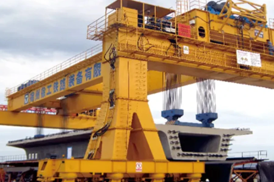 Two views of a 900-ton wheeled mobile gantry crane carrying a road section