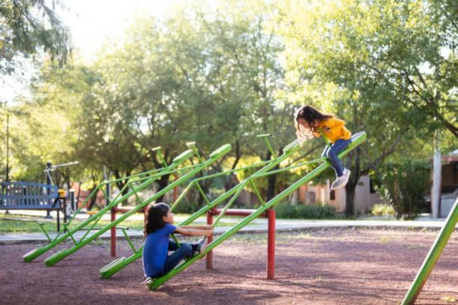 Dos niñas en un balancín en un patio de recreo al aire libre