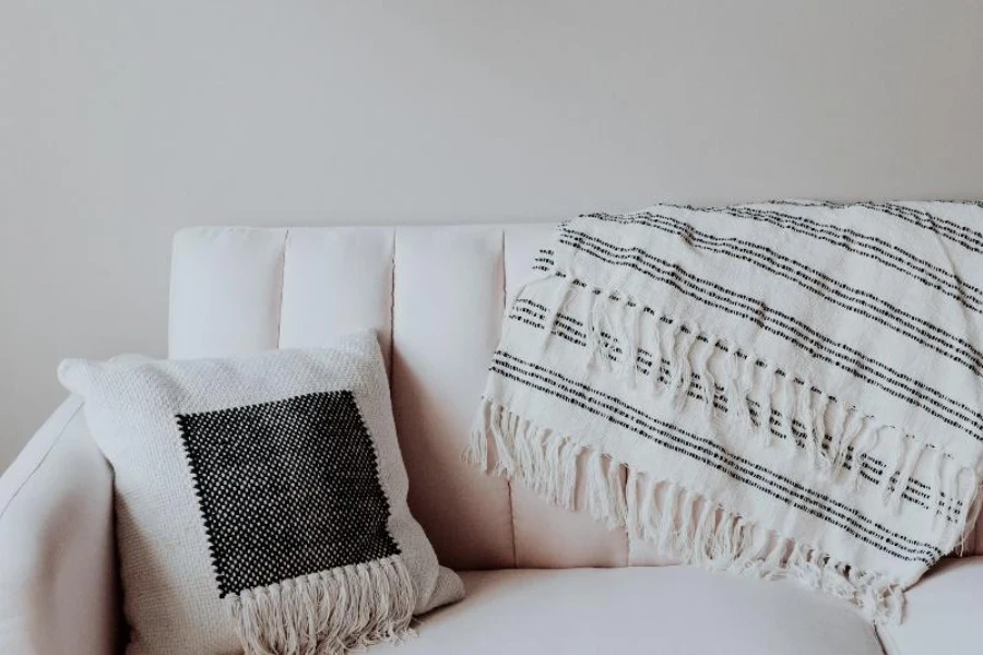 Coussin décoratif blanc et noir avec frange